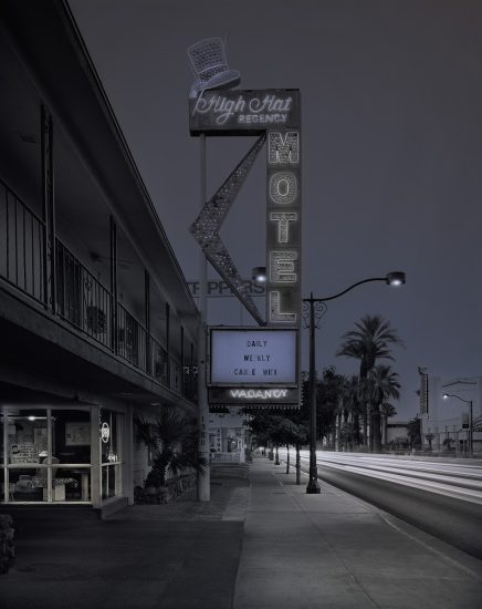A photograph of a motel with its large vintage sign.