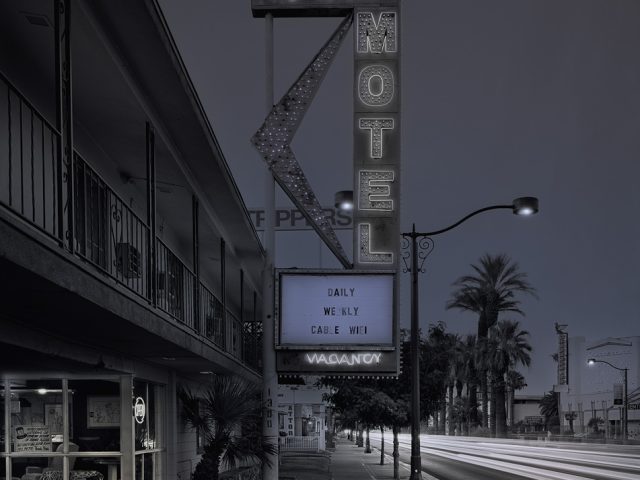 A photograph of a motel with its large vintage sign.