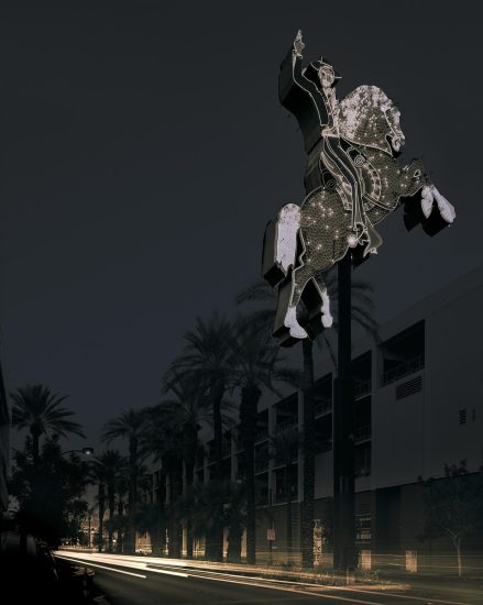 A photograph of a glittering sign for a motel with a man riding a horse.