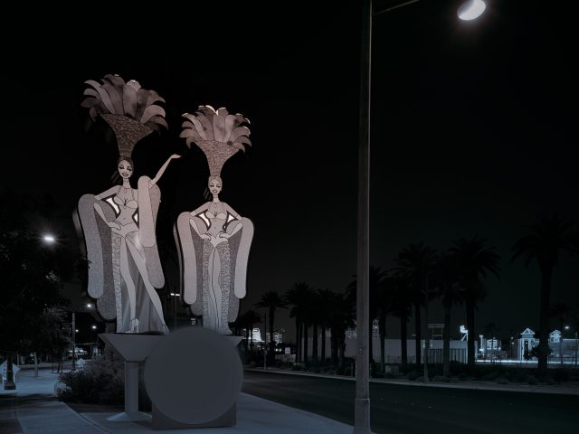 A photograph of two showgirl figures on a street.