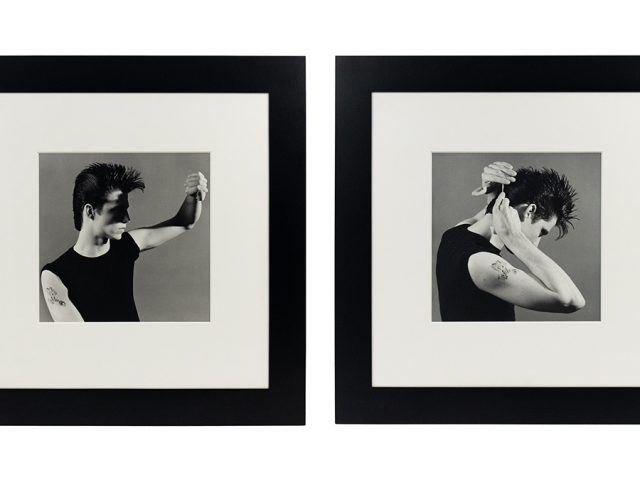 Two black-and-white photographs of the same man in a sleeveless black shirt displayed in white mats and wide black frames.