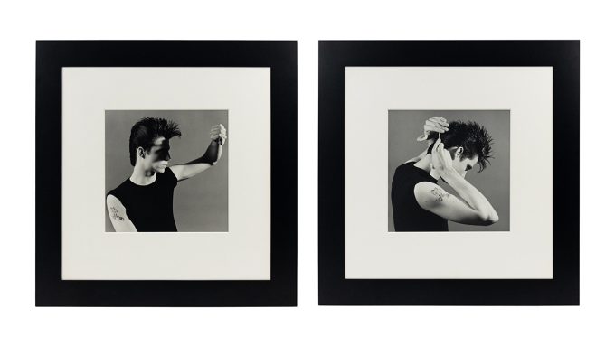 Two black-and-white photographs of the same man in a sleeveless black shirt displayed in white mats and wide black frames.