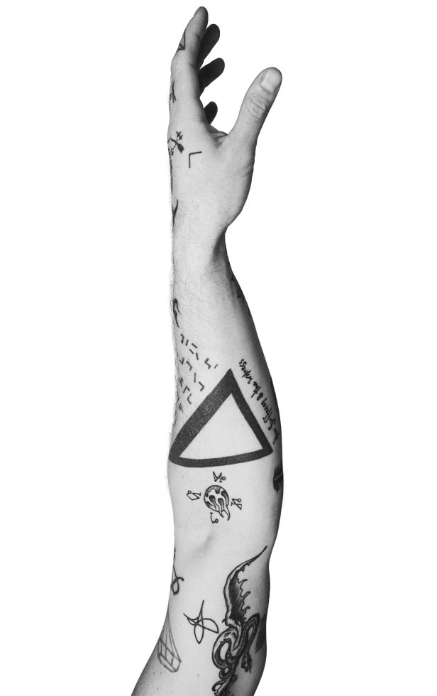 A black and white photograph of a man's arm with tattoos on it against a white background.