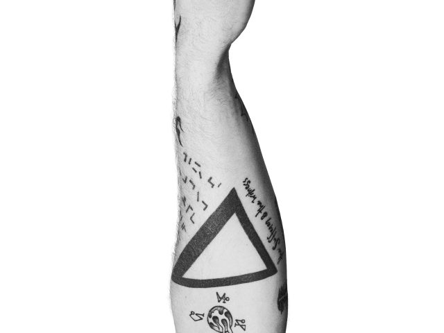 A black and white photograph of a man's arm with tattoos on it against a white background.