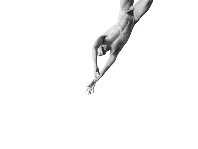 A black and white photograph of a nude man floating through the air on a white background.