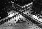 A black and white photograph of cross streets with snow.
