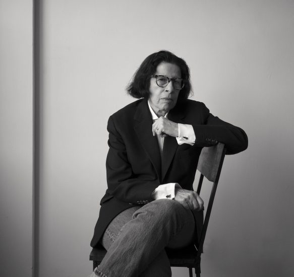 A black and white photograph of a skeptical looking person sitting in a chair.