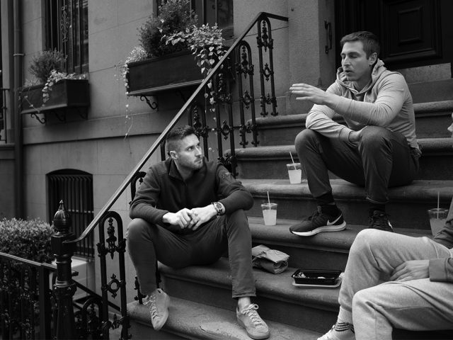 A black and white photograph of doctors sitting on a stoop.