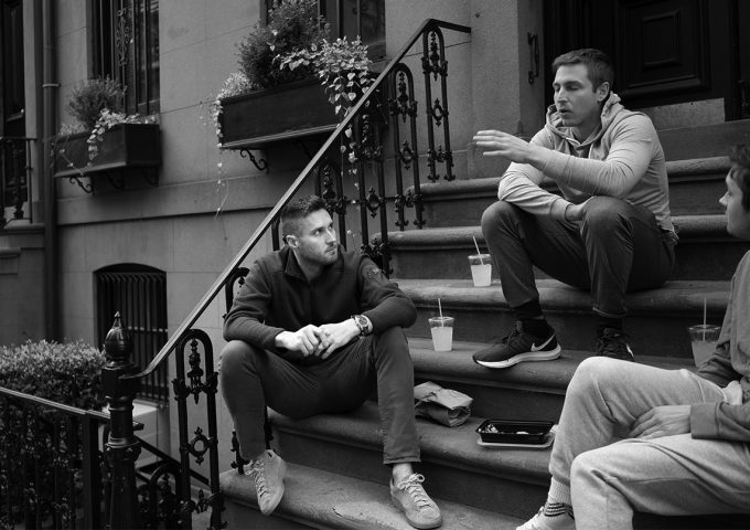 A black and white photograph of doctors sitting on a stoop.