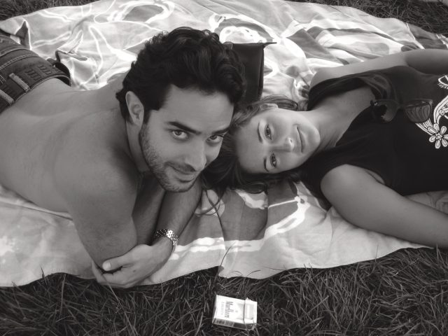 A black and white photograph of two young lovers in the grass.