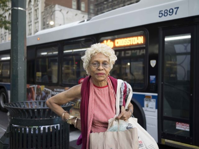 A photograph of a sweet older woman who just missed her bus.