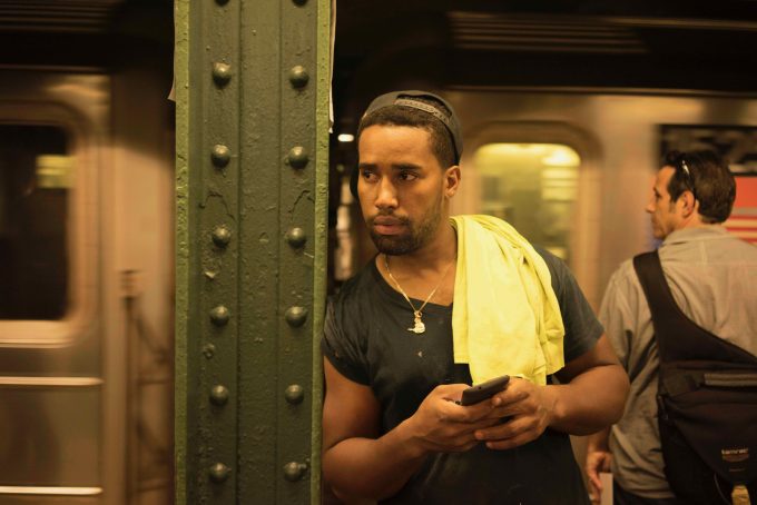 A color photograph of a construction worker waiting for the subway.