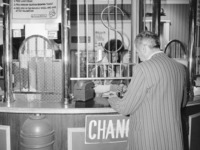 A black and white photograph of a man cashing a check.