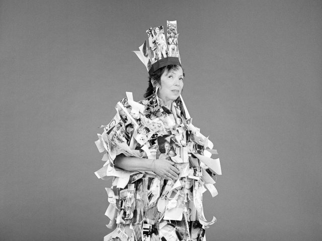 A black and white photograph of a woman covered in small black and white photographic prints.