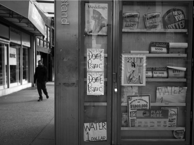A black and white photograph of a newsstand.