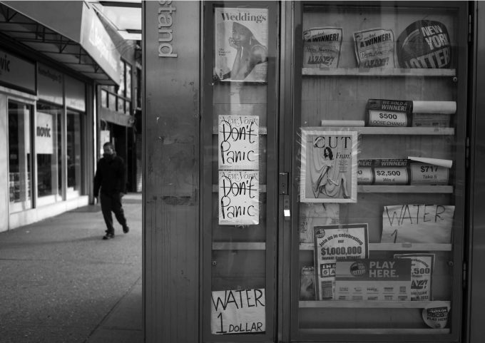 A black and white photograph of a newsstand.