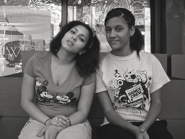A black and white photograph of two young women at the bodega.