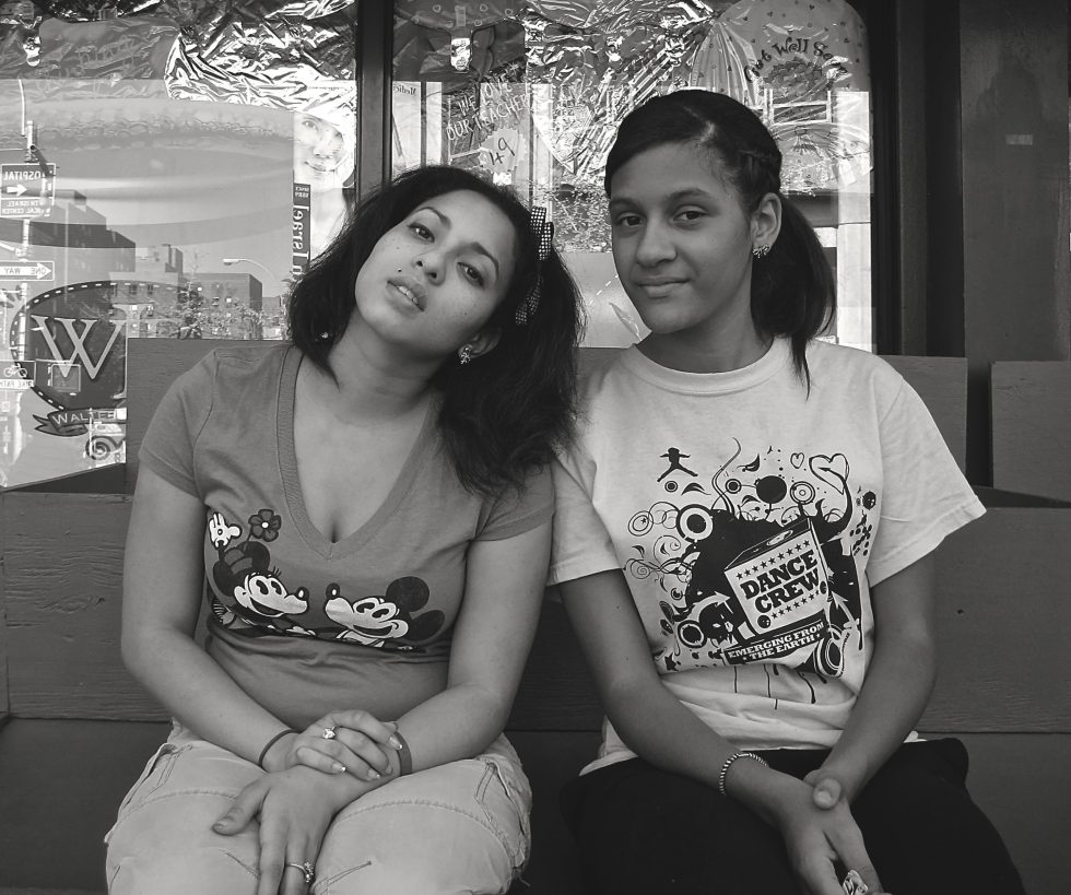 A black and white photograph of two young women at the bodega.
