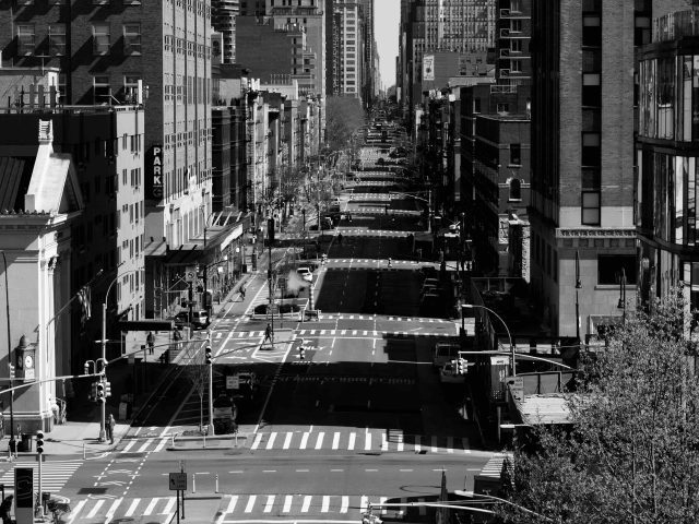 A black and white photograph of a street with no cars photographer from above.