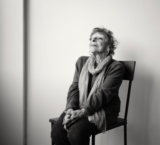 A black and white photograph of an older woman sitting in a chair.