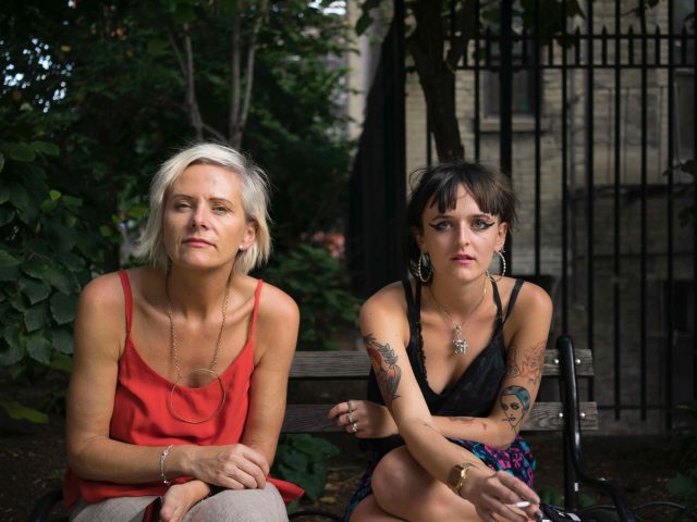 A photograph of a mother and daughter sitting on a park bench.