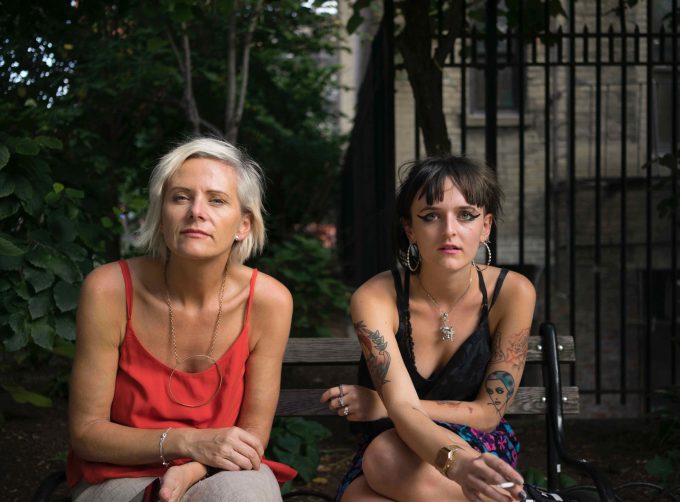 A photograph of a mother and daughter sitting on a park bench.