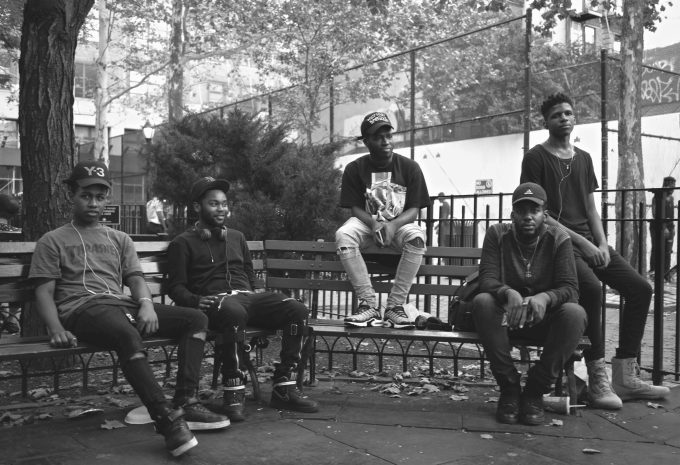 A black and white picture of a bunch of buds on a park bench.