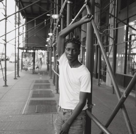 A black and white photograph of a handsome man under scaffolding.