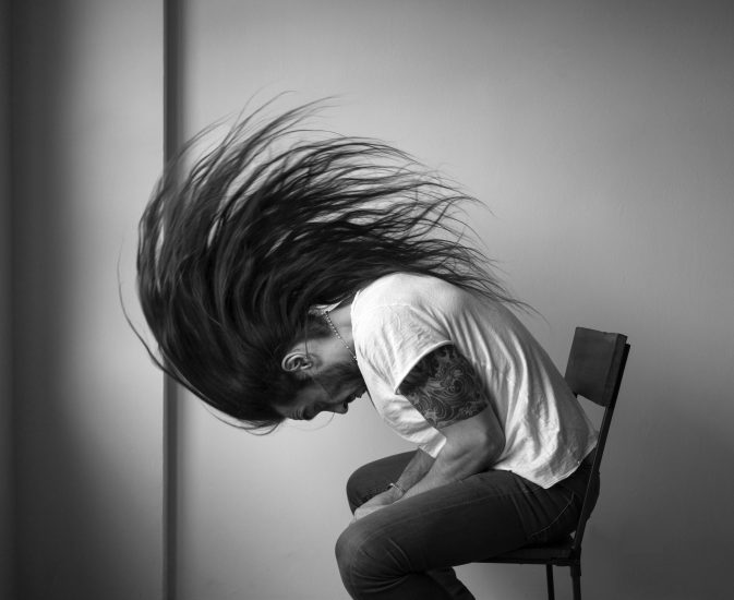 A black and white photograph of a man whipping his hair.
