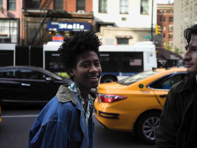 A color photograph of two young people on the street.