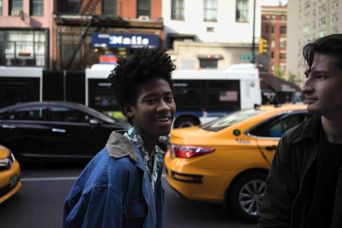A color photograph of two young people on the street.