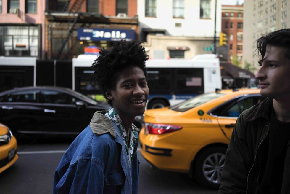A color photograph of two young people on the street.