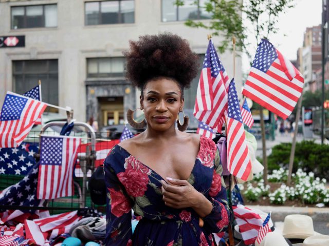 A photograph of a patriotically dressed woman at a parade.