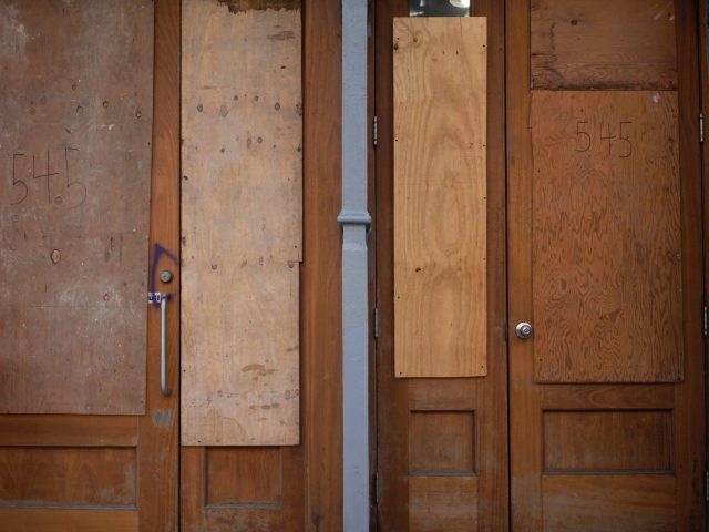 A photograph of boarded up storefront.