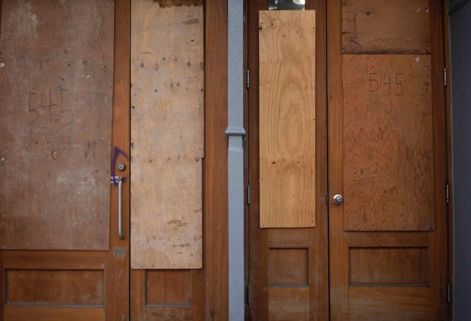 A photograph of boarded up storefront.