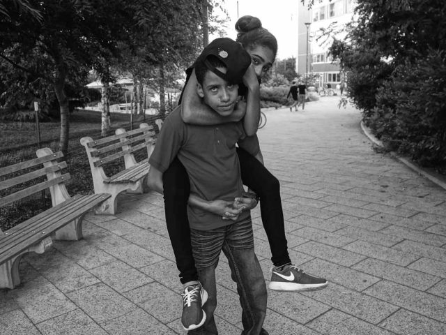 A black and white photograph of a young couple in a park.