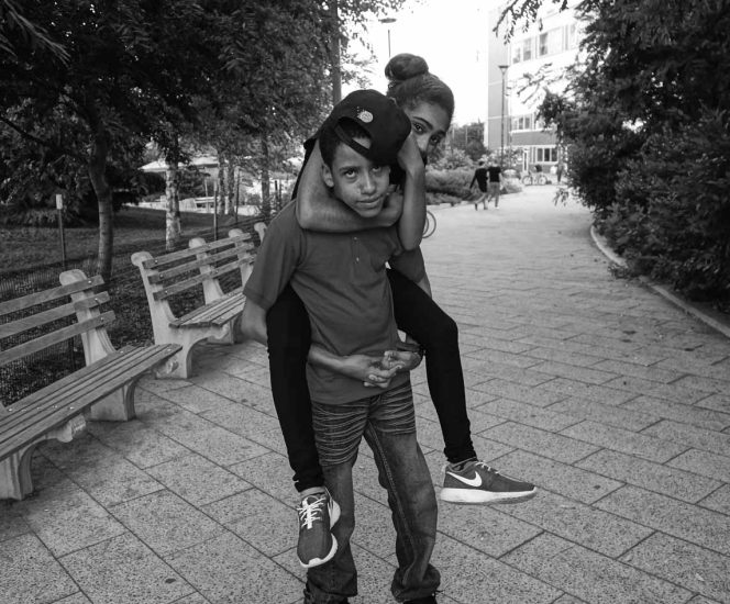 A black and white photograph of a young couple in a park.