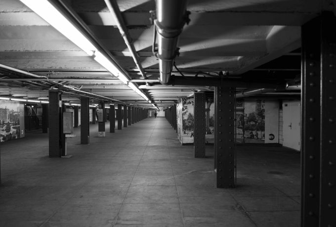 A black and white photograph of an underground subway station.