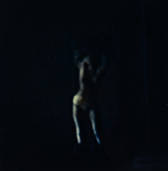 A dark photograph of a subtle silhouette of a woman.