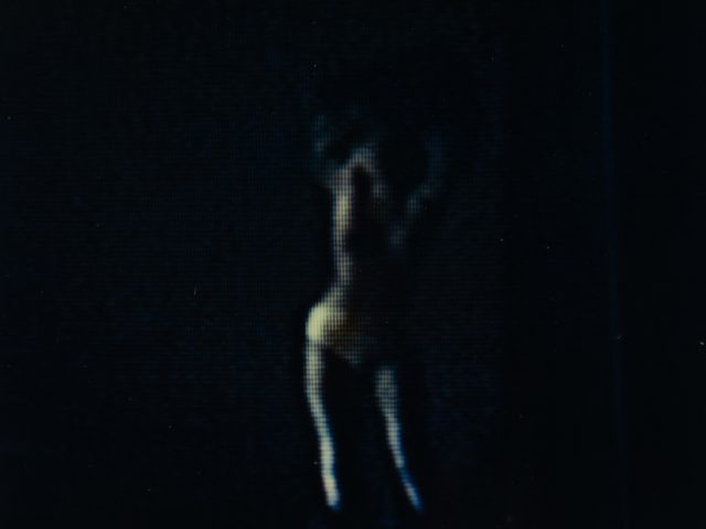 A dark photograph of a subtle silhouette of a woman.