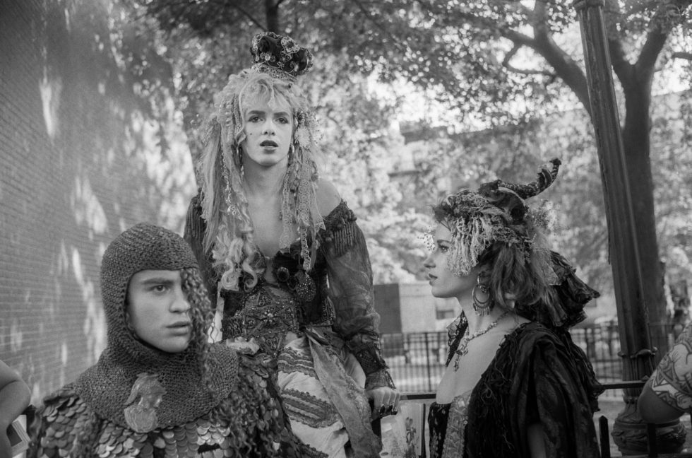 A black and white photograph of a group of people in costumes in a park.