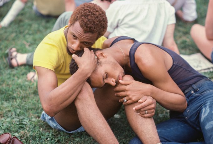A photograph of a young gay couple in a park.