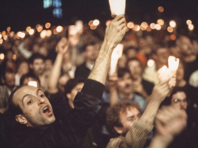 A large protesting crowd holds up candles.