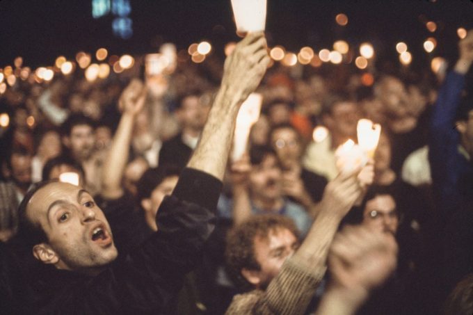 A large protesting crowd holds up candles.