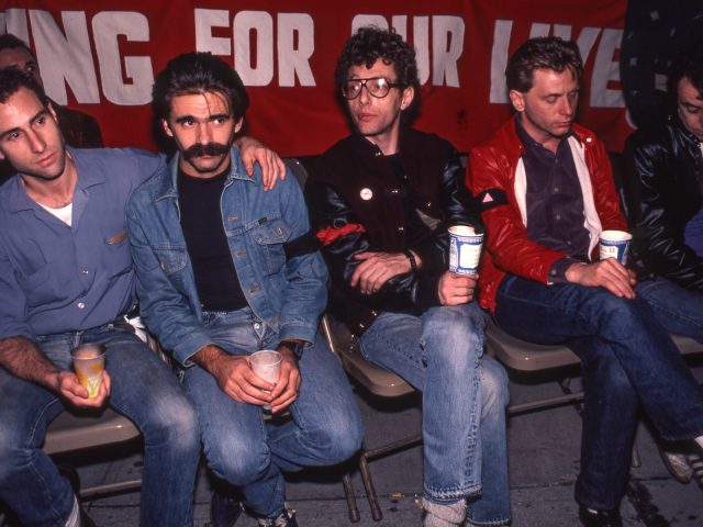 A color photograph of four men at an AIDS vigil.