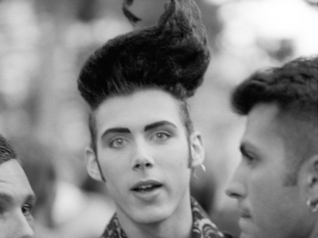 A black and white photograph of a man with wild hair.
