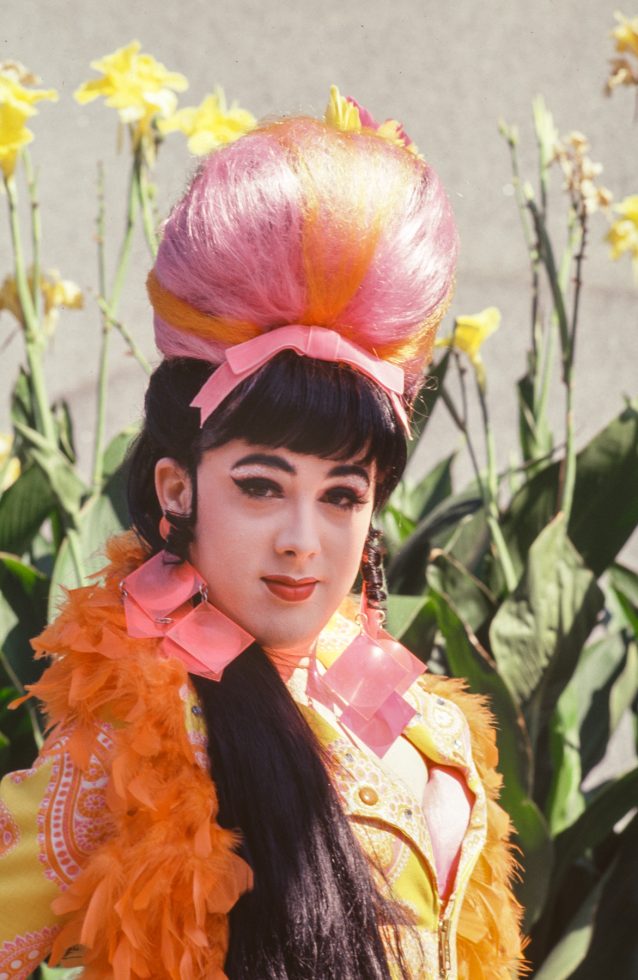 A colorful portrait of a woman in a orange and pink costume in sunshine.