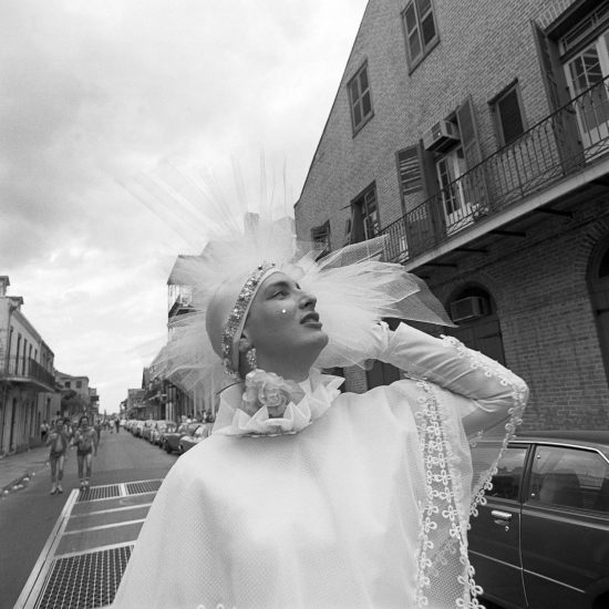 A black and white photograph of a person in a white dress with