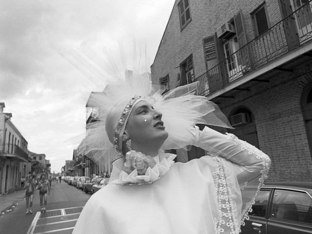 A black and white photograph of a person in a white dress with