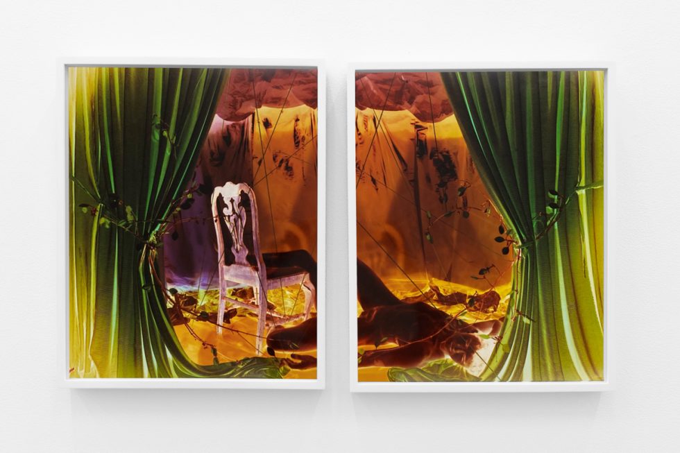 A photograph of a white-walled gallery space with colorful photographs on display.